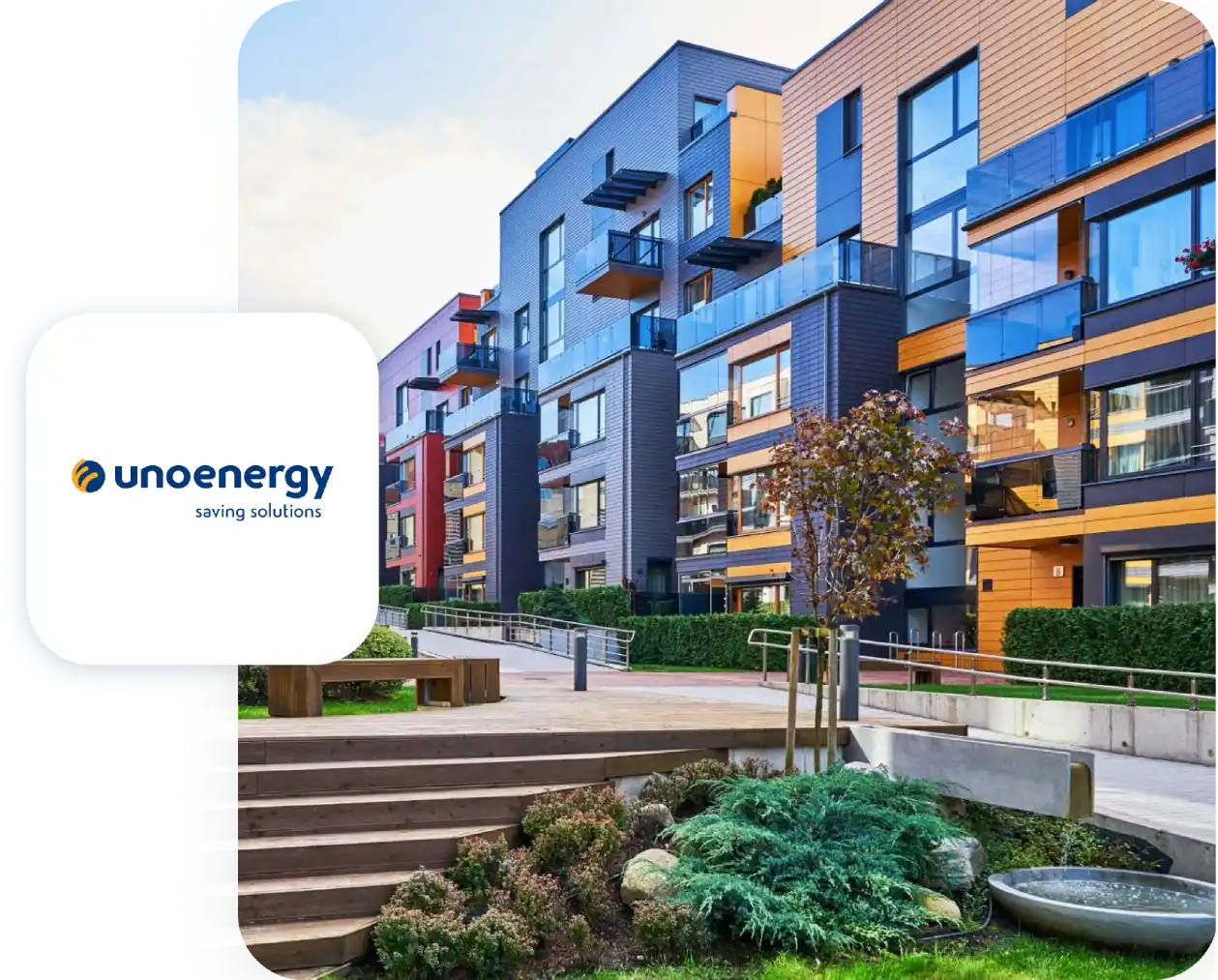 Complesso residenziale moderno con giardino e logo Unoenergy in primo piano.