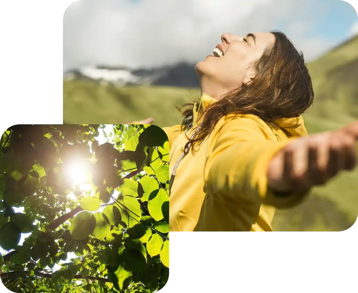 Donna sorridente con giacca gialla all'aperto, sole tra foglie verdi in primo piano.