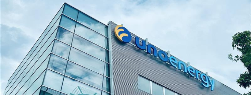 Edificio aziendale moderno con logo Uhoenergy sulla facciata, cielo parzialmente nuvoloso sullo sfondo.