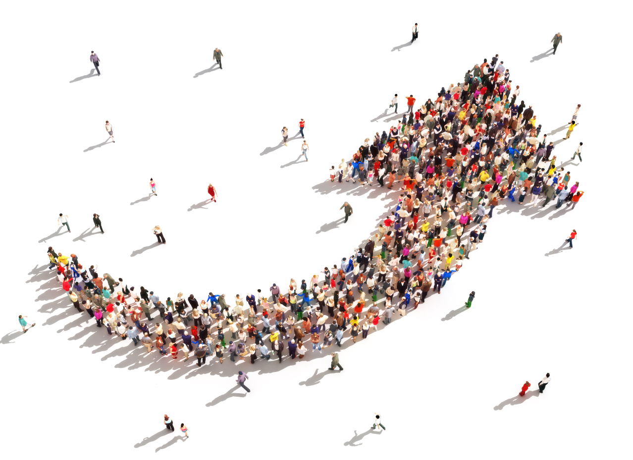 Folla di persone disposte a formare una freccia rivolta verso l'alto su sfondo bianco.