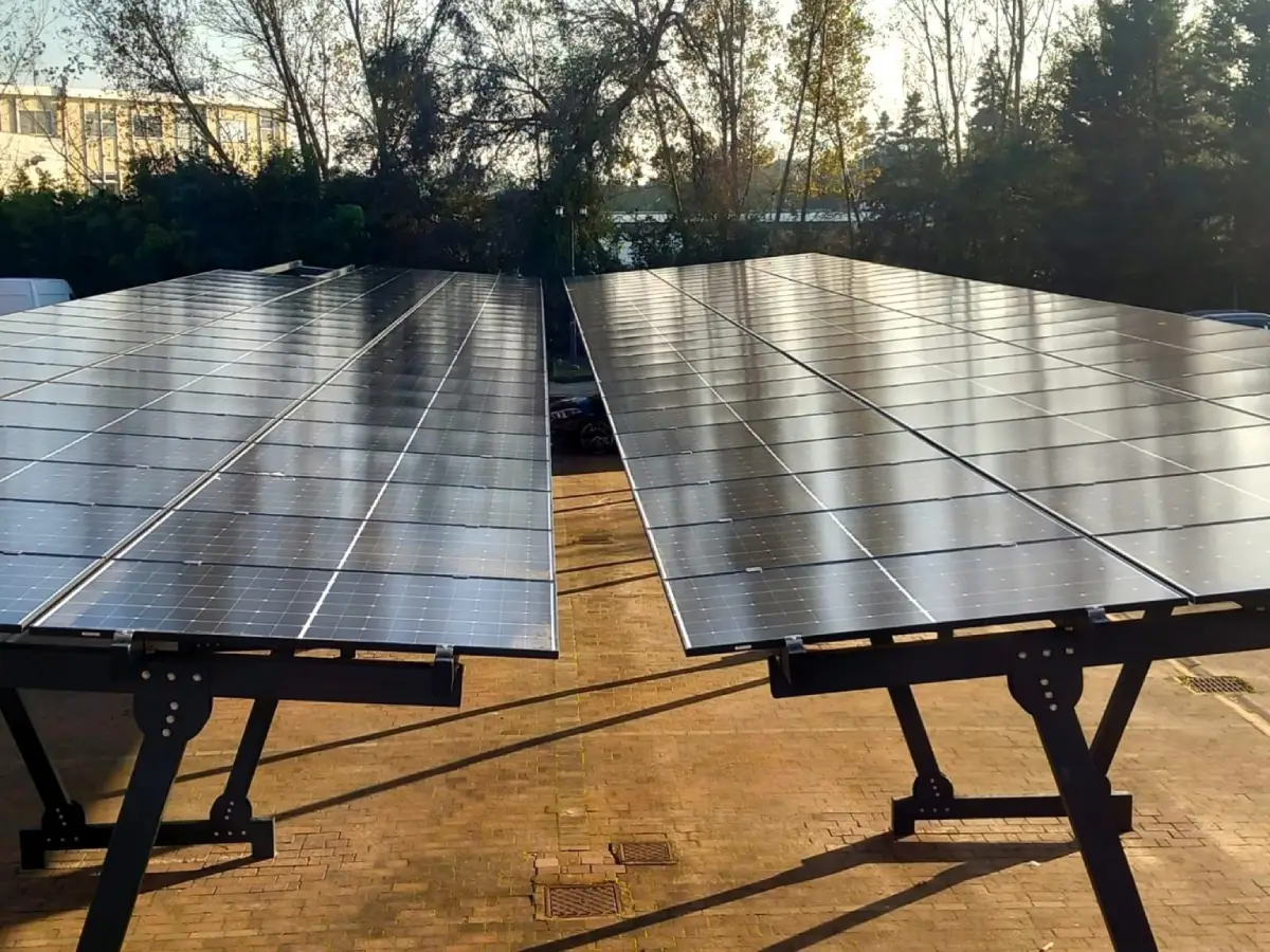 Pannelli solari su tetto al tramonto, cielo limpido e alberi sullo sfondo. Energia solare rinnovabile.