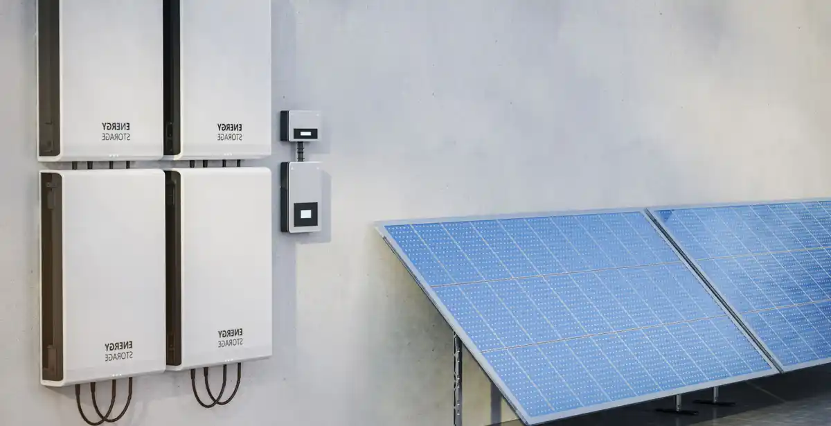 Batterie di accumulo energetico e pannelli solari su parete esterna.