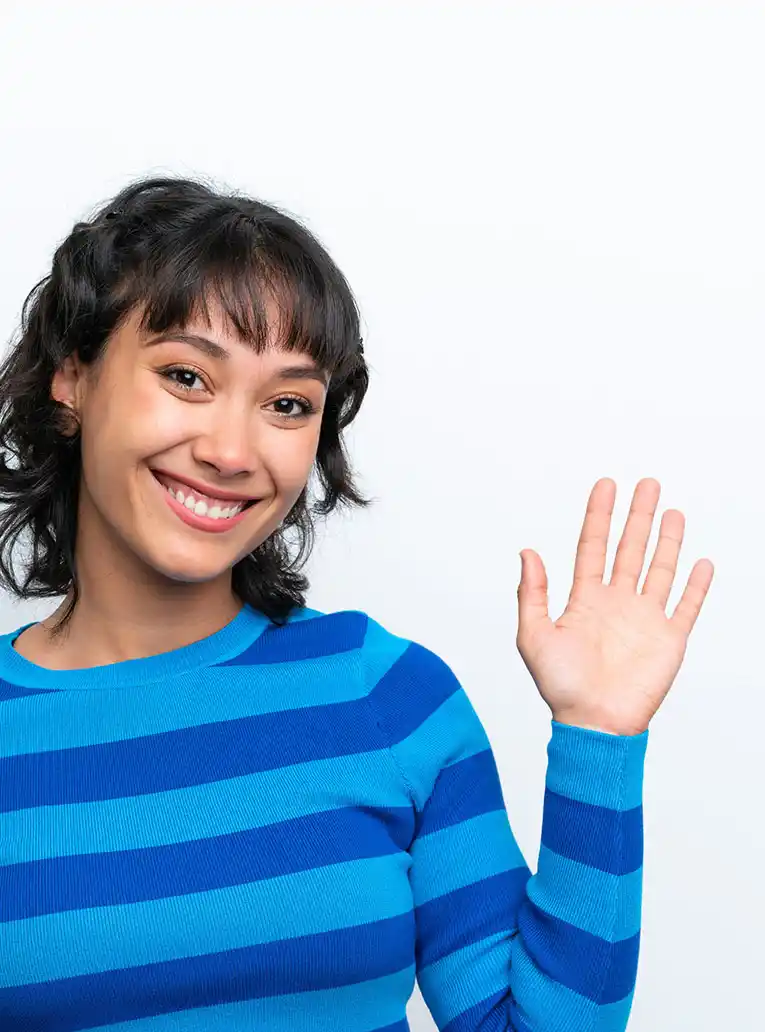 Donna sorridente in maglia a righe blu saluta con la mano sinistra alzata, sfondo bianco.