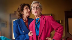 Due donne anziane. Una parla nell'orecchio dell'altra che appare sorpresa