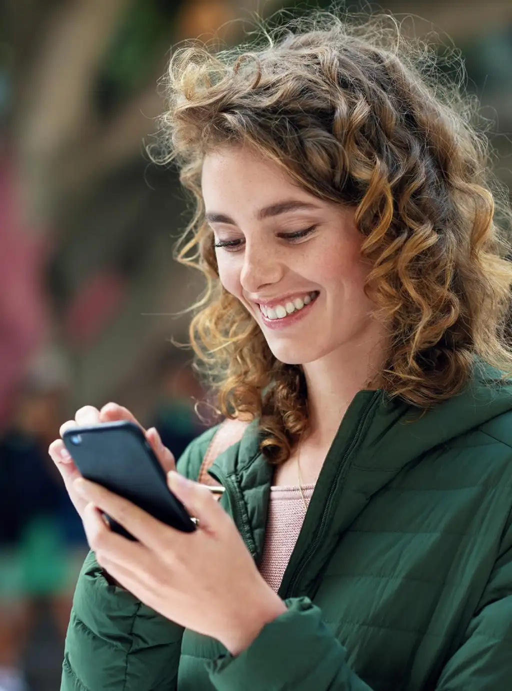 Ragazza sorridente mentre utilizza uno smartphone