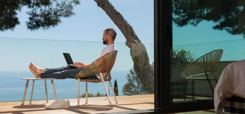 Uomo si rilassa al computer su una terrazza