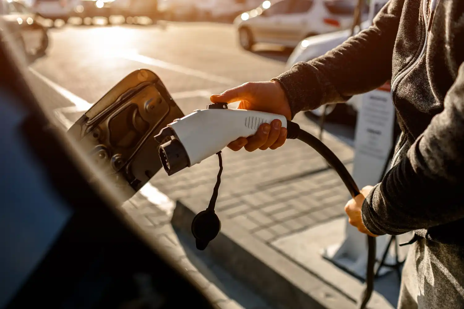 Braccio di un uomo che ricarica l'auto elettrica